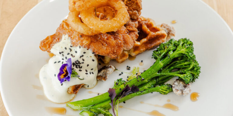 Mimosa Chicken Croffle with crispy chicken, onion rings and broccolini